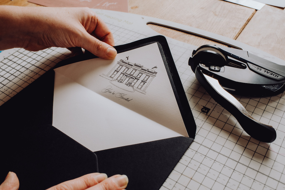 white envelope liner with venue illustration inside a black envelope