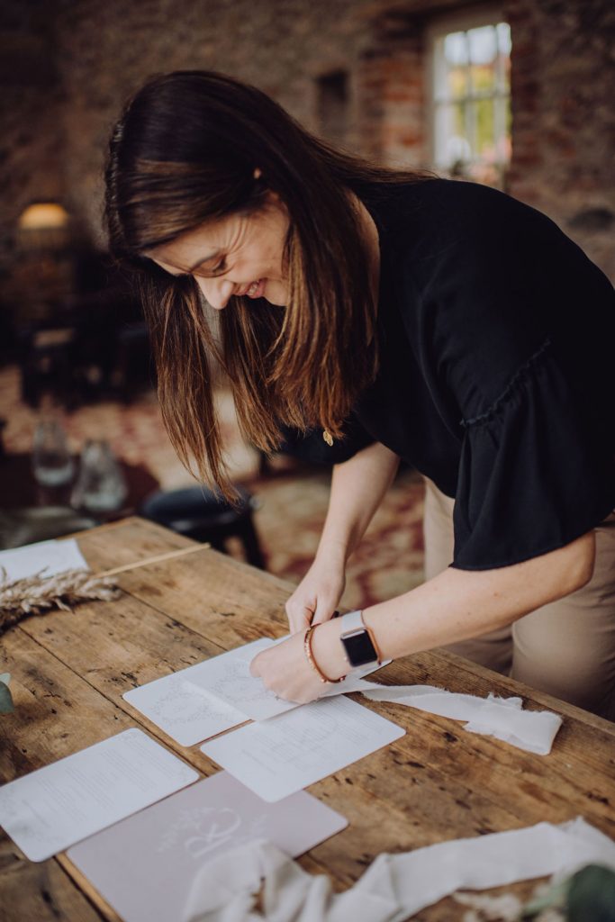 image of Laura assembling an elegant wedding invitation suite from the collection