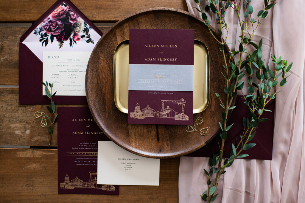 Bespoke wedding stationery suite featuring burgundy card stock, gold hot foil with a custom venue illustration and floral envelope liner